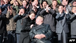 Kim Jong Un y su hija junto a funcionarios e ingenieros del régimen norcoreano, que contribuyeron a la prueba de fuego del nuevo misil balístico intercontinental. (Foto: KCNA VIA KNS / AFP)