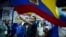 El candidato presidencial Fernando Villavicencio ondea una bandera de Ecuador en un acto de campaña en un colegio minutos antes de ser asesinado a tiros a la salida de ese recinto educativo en Quito, Ecuador, el miércoles 9 de agosto de 2023 (API vía AP)