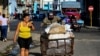 Un hombre empuja una carretilla con sacos de alimentos por una calle de La Habana. (Yamil Lage/AFP)