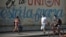 Residentes de La Habana pasan frente a un cartel con propaganda del régimen durante la pandemia de coronavirus, el 13 de abril del 2020.
