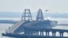 Un helicóptero arroja agua sobre el puente que conecta la península de Crimea con el territorio continental ruso sobre el estrecho de Kerch.