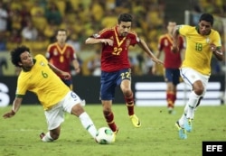 El centrocampista de la selección española Jesús Navas (c) lucha por el balón con los brasileños Marcelo Vieira (i) y Paulinho (d) durante la final de la Copa Confederaciones.