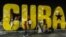 Niños juegan en un gran cartel de Cuba.