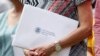 Una mujer sostiene los certificados de ciudadanía de EEUU en un sobre. Raj Mehta-USA TODAY vía Reuters.