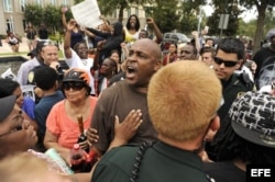 La policía pide a Shawn Caldwell (C) que se calme, mientras discute con un partidario de George Zimmerman.