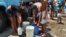 Cubanos se abastecen de agua en pipas.