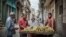 Cubanos compran plátanos a un vendedor ambulante en La Habana, en diciembre de 2018. 