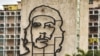 Un hombre camina frente al edificio del Ministerio del Interior con la imagen de Ernesto "Che" Guevara.