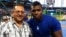 El periodista Edemio Navas (i) junto al jardinero derecho de los Dodgers de Los Ángeles, Yasiel Puig (d).
