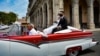 Una pareja de recién casados se pasea por La Habana en un auto de alquiler. Los negocios privados se han visto muy afectados durante la pandemia en Cuba. (YAMIL LAGE / AFP)