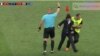 Un agente de seguridad detiene a una de las personas que invadió la cancha en la final del mundial de fútbol. 