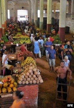 ARCHIVO. Trabajadores en un mercado ofertan sus productos.