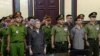 el activista Luu Van Vinh (izq.) y otros acusados ​​comparecen ante el tribunal en la ciudad de Ho Chi Minh, el 5 de octubre de 2018. 