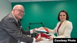 Sviatlana Tsikhanouskaya, presidente del Gabinete Unido para la Transición en Bielorrusia, intercambia bandera con el Dr. Orlando Gutiérrez Boronat, secretario general de la Asamblea de la Resistencia Cubana.