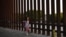 Niña centroaméricana camina junto a la valla México-EEUU
