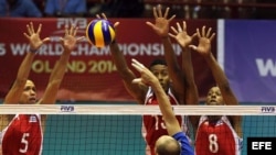 Los jugadores cubanos Leandro Macías (izq), David Fiel (cen) y Rolando Cepeda (der), rechazan el ataque del ruso Nikolay Pavlov, durante el partido Cuba-Rusia de la Liga Mundial de Voleibol celebrado en La Habana (Cuba).